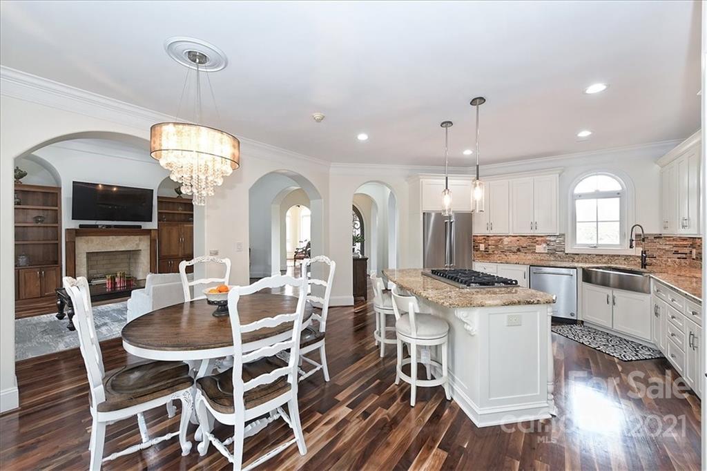 3425 Millstone Creek Road Lancaster, SC 29720 - Photo 15 of 48 a kitchen with stainless steel appliances granite countertop a stove a sink dishwasher a dining table and chairs with wooden floor