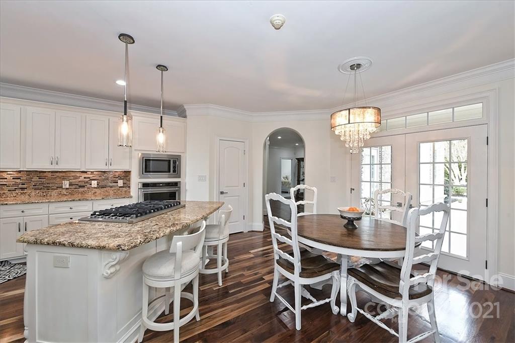 3425 Millstone Creek Road Lancaster, SC 29720 - Photo 17 of 48 a kitchen with stainless steel appliances granite countertop a stove a sink a dining table and chairs with wooden floor