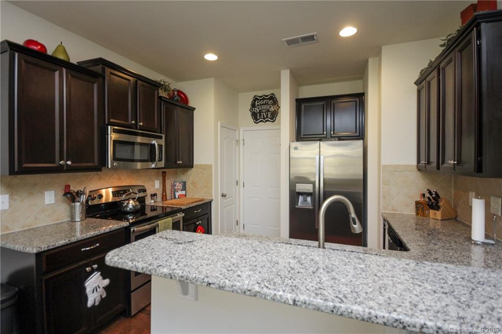 78126 Rillstone Drive, Unit 209 Lancaster, SC 29720 - Photo 5 of 24 a kitchen with stainless steel appliances granite countertop a sink stove and refrigerator