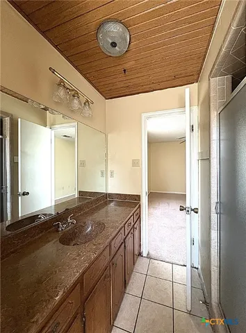 a bathroom with a granite countertop sink and mirror