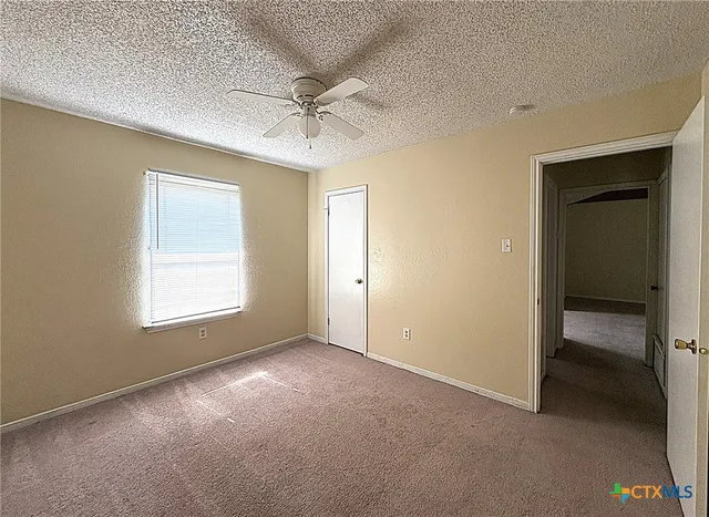 a view of a livingroom with a ceiling fan and window