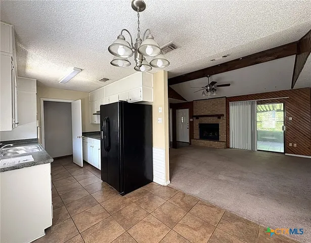 a view of a kitchen with a sink and a refrigerator