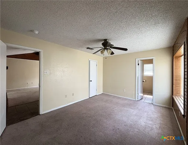 a view of empty room with cabinet and ceiling fan