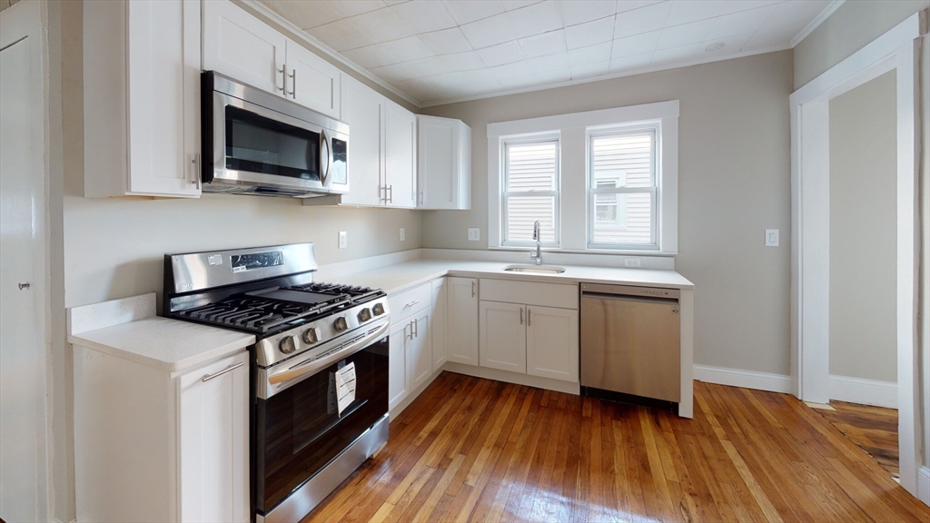 5 Edgar Terrace, Unit 2 Somerville, MA 02145 - Photo 1 of 6 a kitchen with a stove a sink and a microwave