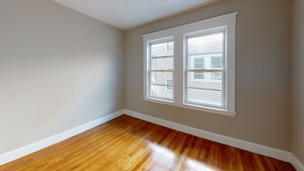 5 Edgar Terrace, Unit 2 Somerville, MA 02145 - Photo 3 of 6 an empty room with wooden floor and windows