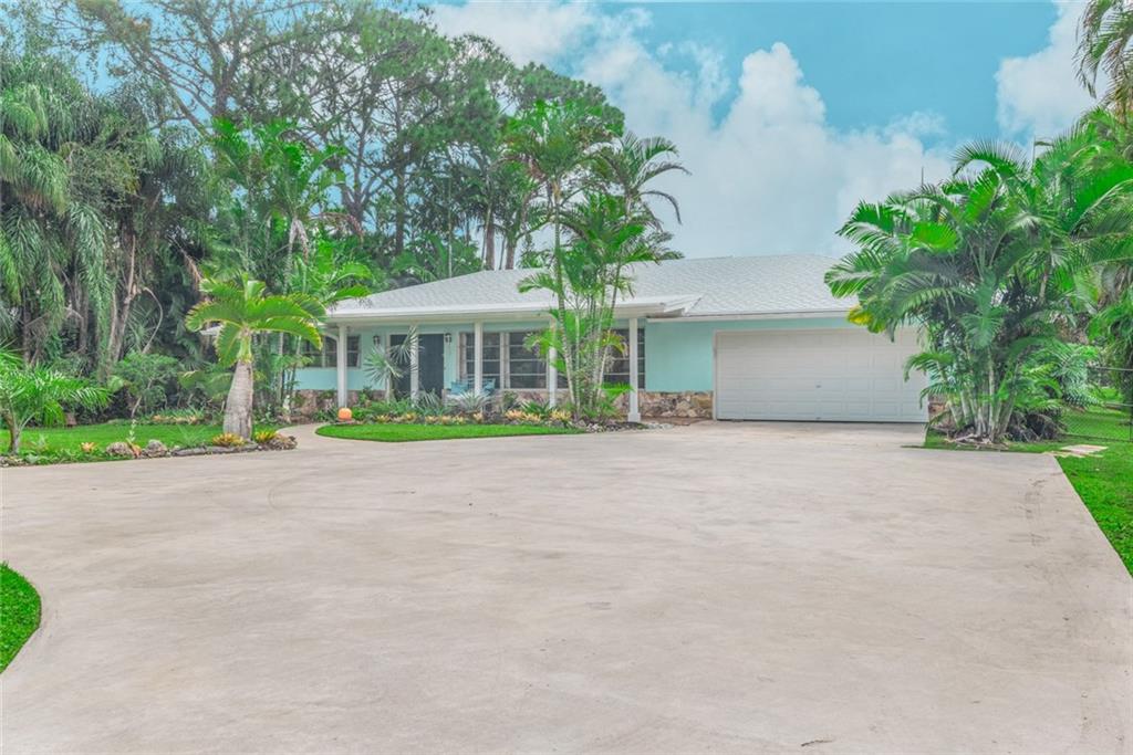 a view of a house with a yard and tree s
