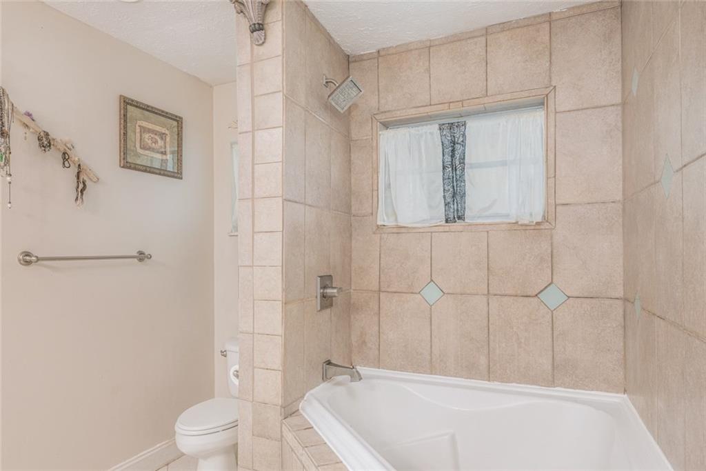 1128 Northwest Fork Road Stuart, FL 34994 - Photo 12 of 23 a bathroom with a bathtub a toilet and a shower