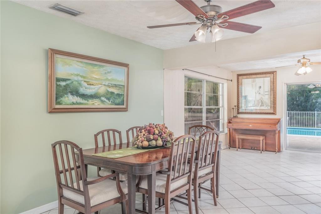 1128 Northwest Fork Road Stuart, FL 34994 - Photo 5 of 23 a dining room with furniture a window and a chandelier