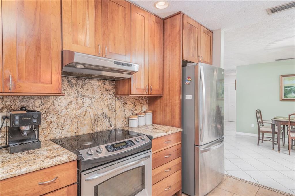 1128 Northwest Fork Road Stuart, FL 34994 - Photo 9 of 23 a kitchen with granite countertop a stove and a refrigerator