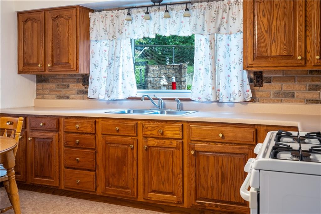 2509 Spring Street Pittsburgh, PA 15210 - Photo 3 of 31 a kitchen with granite countertop wooden cabinets a sink and a window