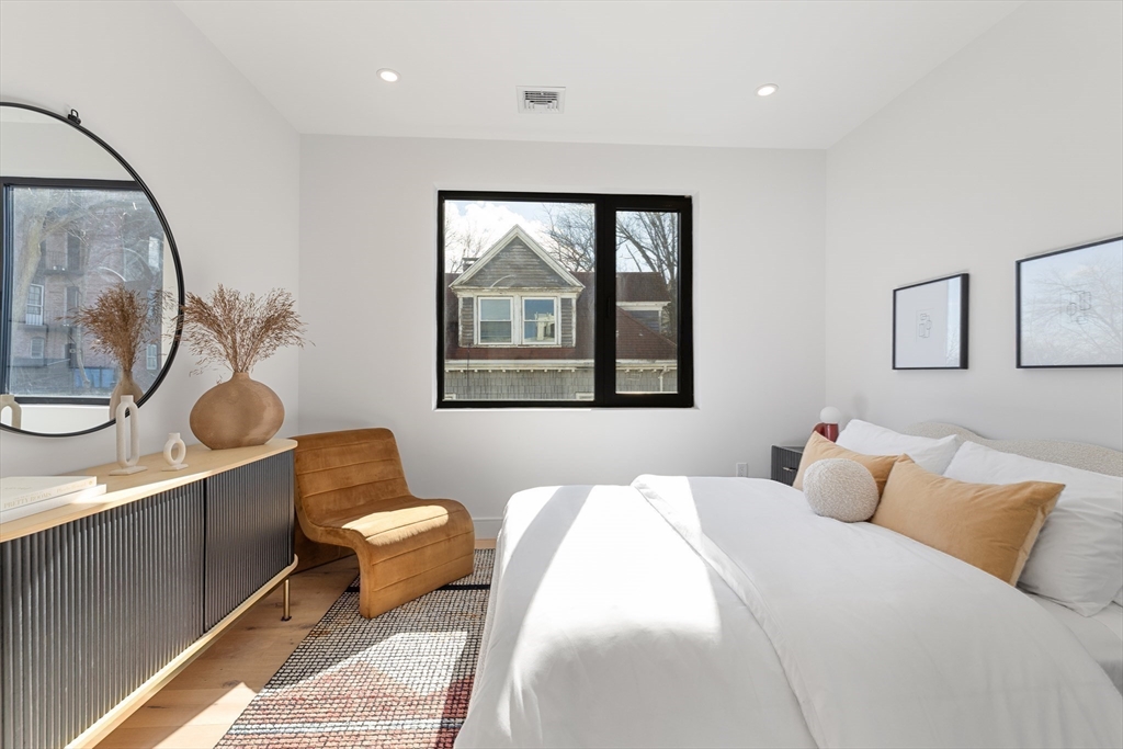 41 University Road, Unit 3 Brookline, MA 02445 - Photo 14 of 21 a spacious bedroom with a bed a mirror and a large window