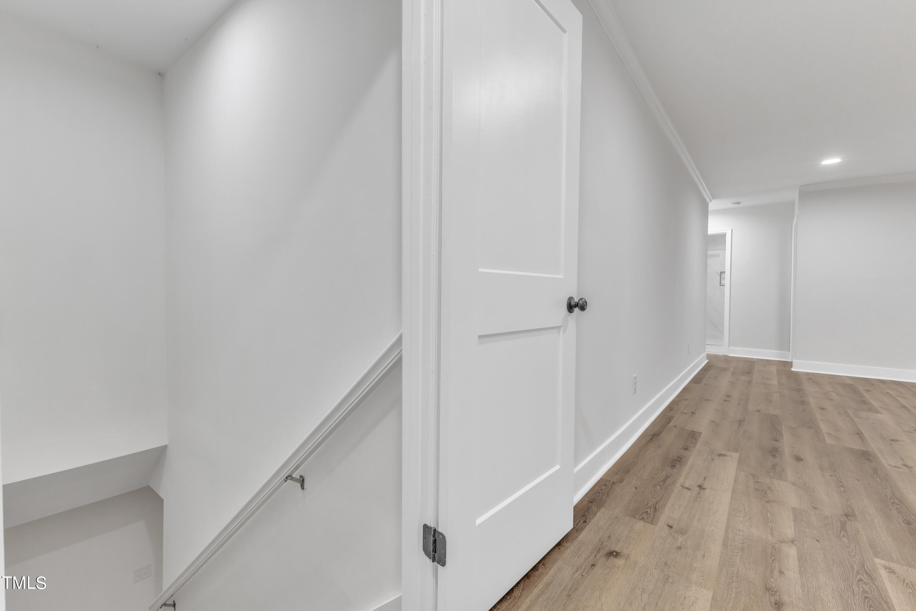 Undisclosed Address Raleigh, NC 27615 - Photo 17 of 26 a view of a hallway with wooden floor and staircase