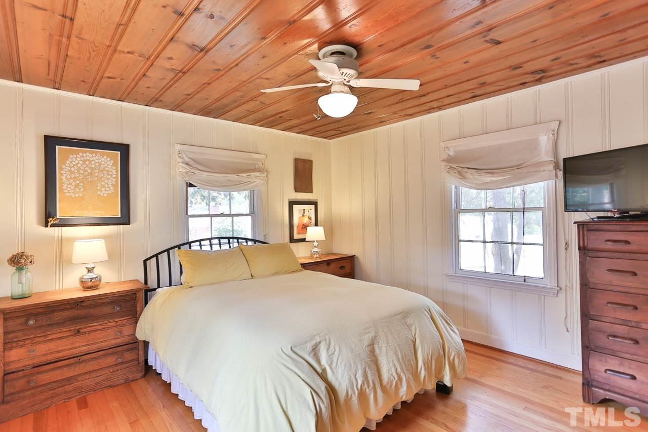 300 East Whitaker Mill Road Raleigh, NC 27608 - Photo 12 of 25 a bedroom with a large bed and a chandelier