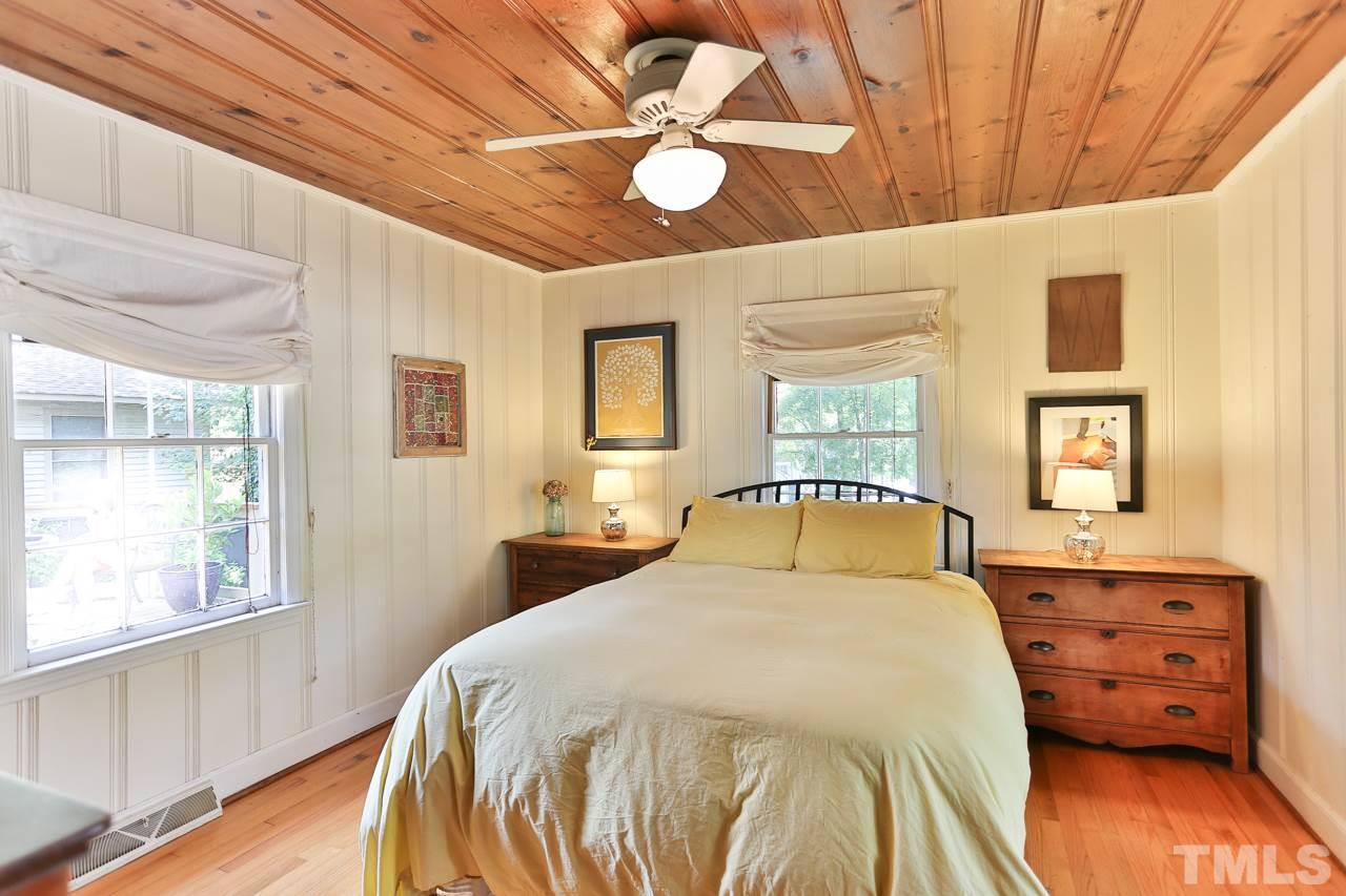 300 East Whitaker Mill Road Raleigh, NC 27608 - Photo 13 of 25 a bedroom with a bed and wooden floor
