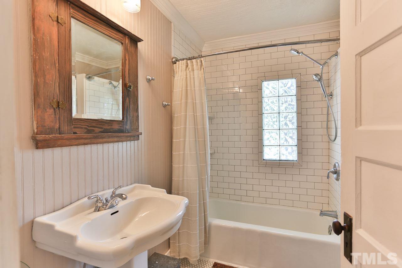 300 East Whitaker Mill Road Raleigh, NC 27608 - Photo 15 of 25 a bathroom with a sink a mirror and a bathtub