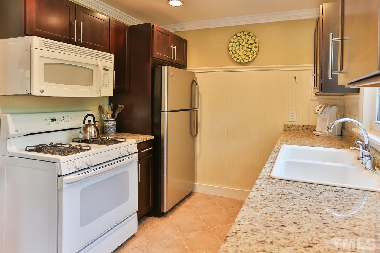 300 East Whitaker Mill Road Raleigh, NC 27608 - Photo 8 of 25 a kitchen with a refrigerator sink stove and cabinets