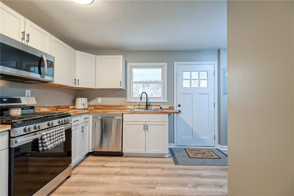 110 Neville Road Beaver, PA 15009 - Photo 10 of 22 a kitchen with stainless steel appliances granite countertop a stove a sink and a microwave