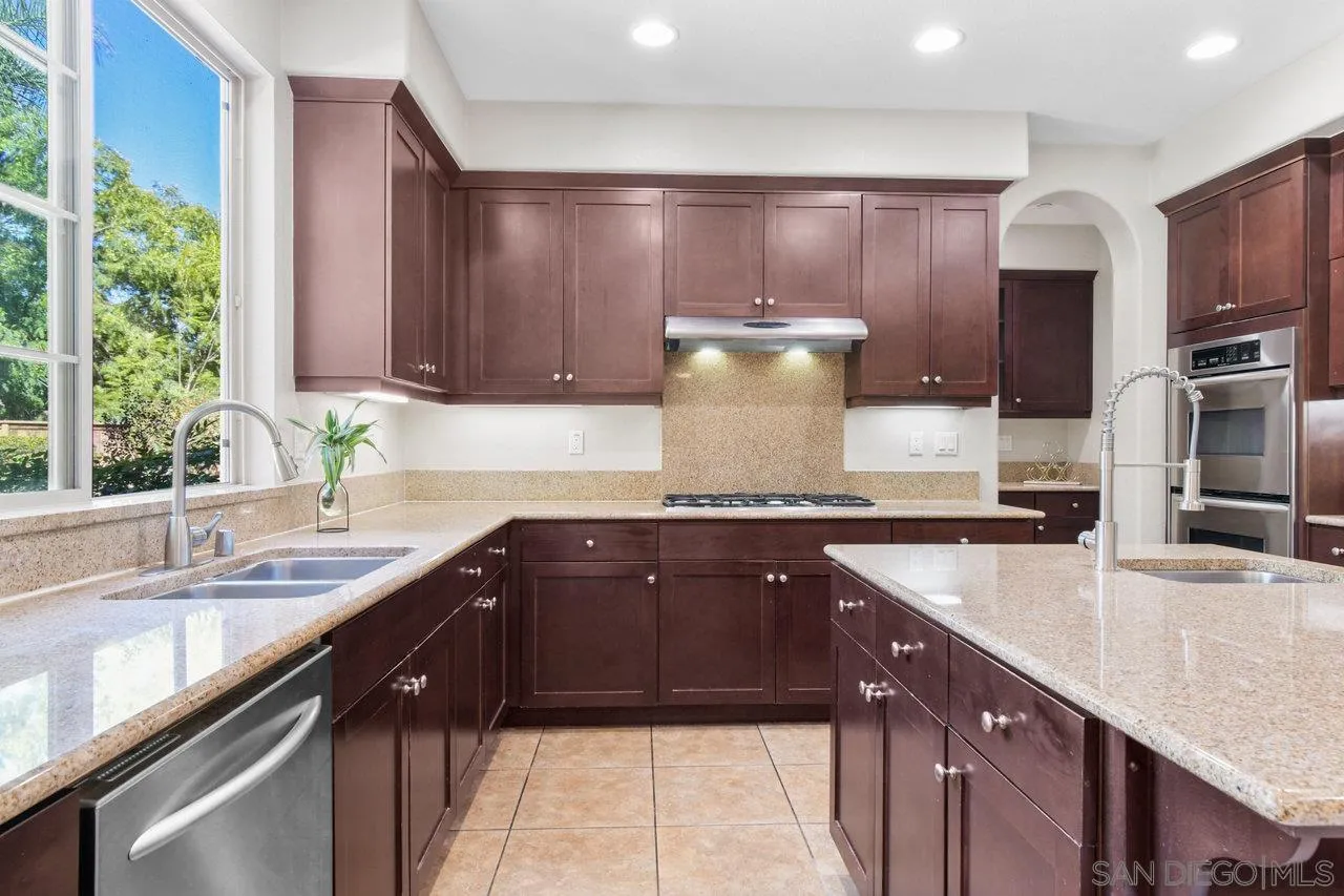 2957 Ranch Gate Road Chula Vista, CA 91914 - Photo 13 of 75 a kitchen with kitchen island granite countertop a sink stainless steel appliances and cabinets