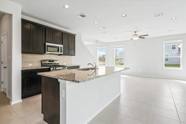a kitchen with stainless steel appliances granite countertop a sink and a refrigerator