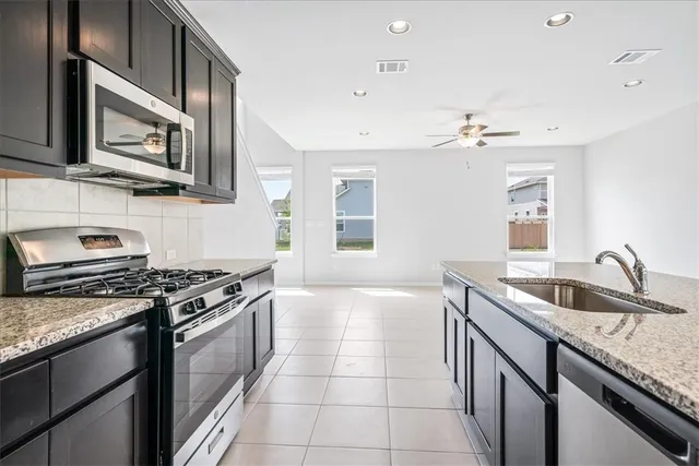 a kitchen with stainless steel appliances granite countertop a sink stove and microwave