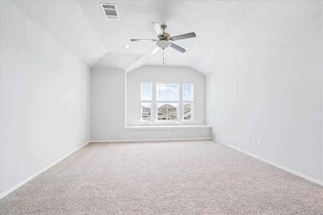 an empty room with a ceiling fan and window