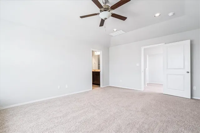 an empty room with ceiling fan and window