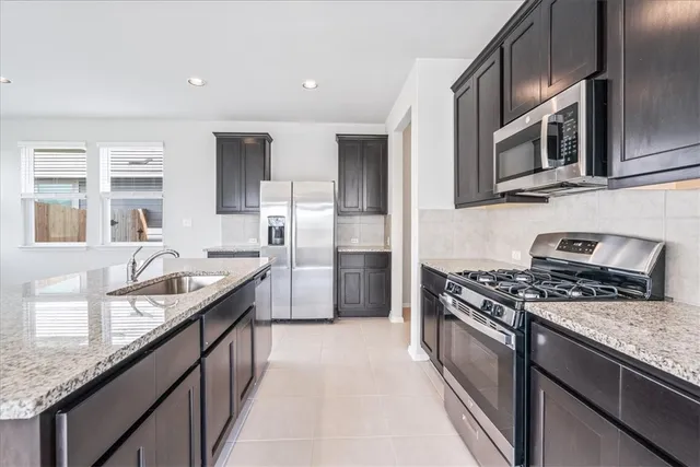a kitchen with stainless steel appliances granite countertop a sink and a stove