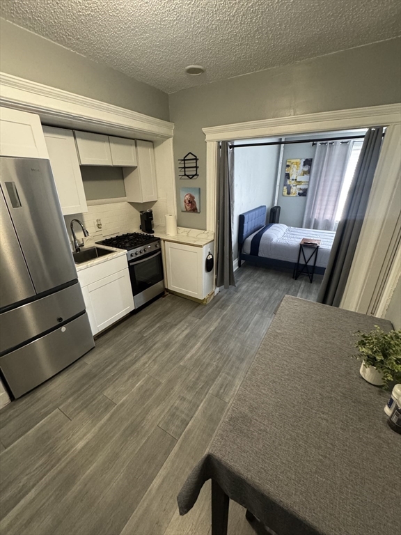 285 Lynn Shore Drive, Unit 203 Lynn, MA 01902 - Photo 2 of 13 a kitchen with a refrigerator and a stove