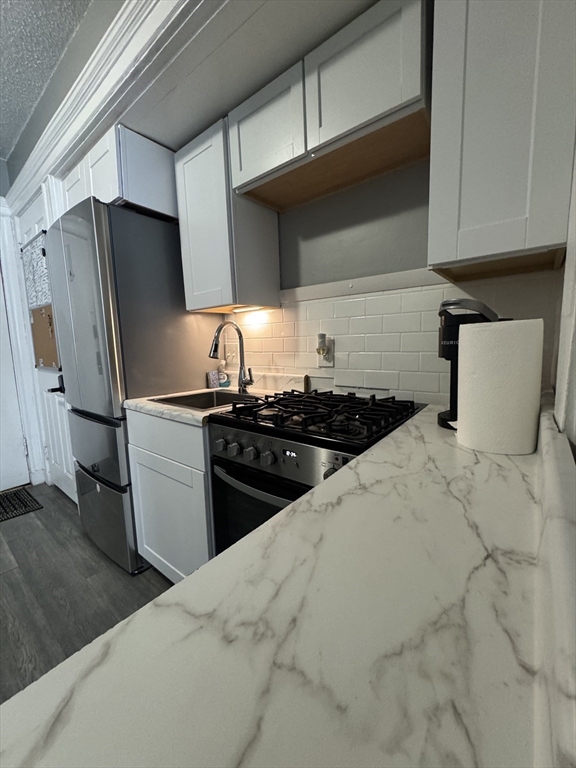 285 Lynn Shore Drive, Unit 203 Lynn, MA 01902 - Photo 6 of 13 a kitchen with stainless steel appliances a sink stove and refrigerator