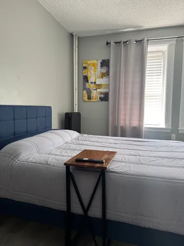 a bedroom with a bed and a potted plant