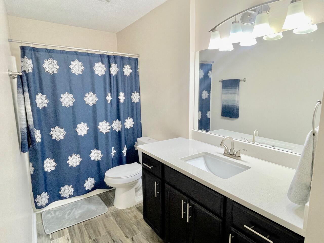 115 Palmetto Drive Crestview, FL 32539 - Photo 18 of 27 a bathroom with a sink a toilet and shower curtain