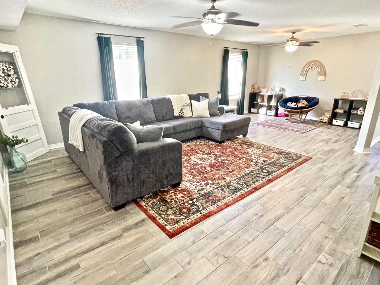 115 Palmetto Drive Crestview, FL 32539 - Photo 4 of 27 a living room with furniture and a wooden floor