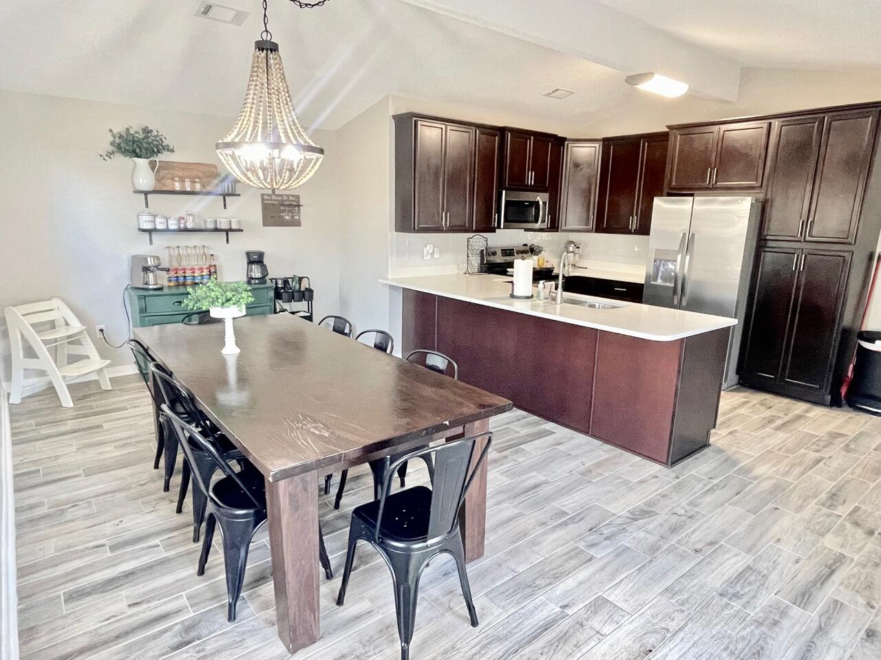 115 Palmetto Drive Crestview, FL 32539 - Photo 8 of 27 a kitchen with stainless steel appliances a table chairs refrigerator and microwave
