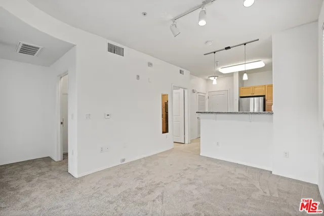 a view of a kitchen with a refrigerator and a sink
