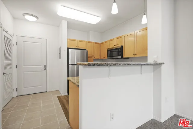 a view of a kitchen with a sink and refrigerator