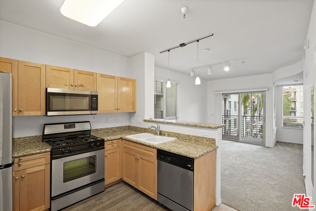 100 South Alameda Street, Unit 346 Los Angeles, CA 90012 - Photo 7 of 24 a kitchen with stainless steel appliances granite countertop a sink stove and microwave