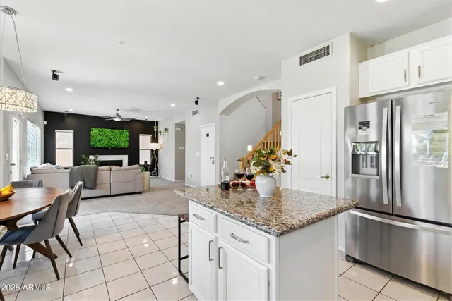 a kitchen with stainless steel appliances granite countertop a refrigerator and a stove top oven