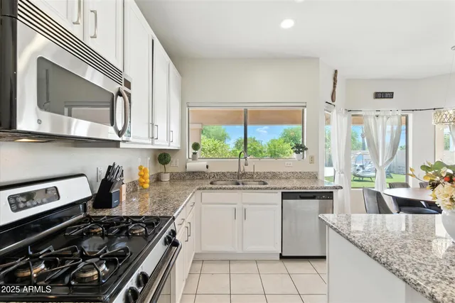 a kitchen with stainless steel appliances granite countertop a stove a sink and a microwave