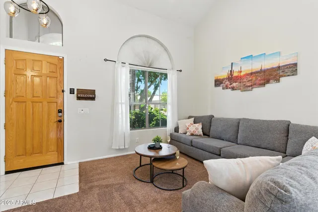 a living room with furniture a window and a chandelier