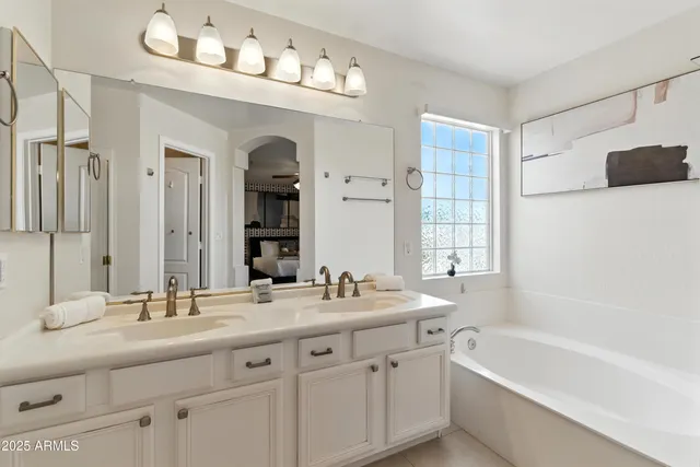 a bathroom with a double vanity sink mirror double and bathtub