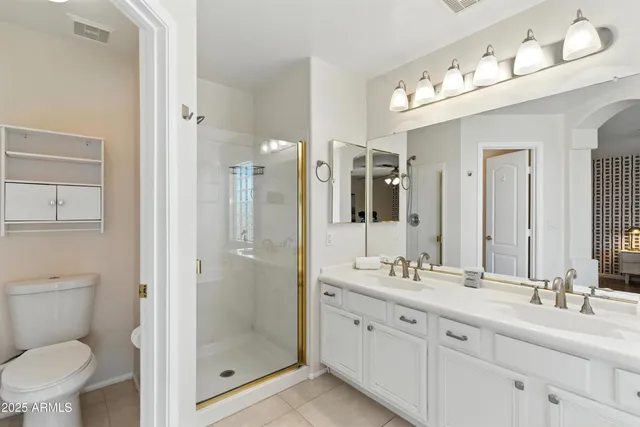a bathroom with a granite countertop sink mirror and toilet