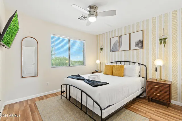a bedroom with a bed a chandelier and a window