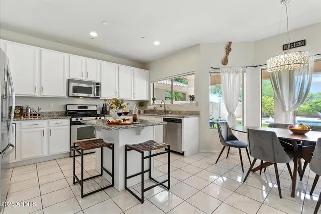 a kitchen with a sink white cabinets and appliances