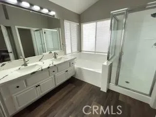 a bathroom with a double vanity sink a mirror and a bathtub