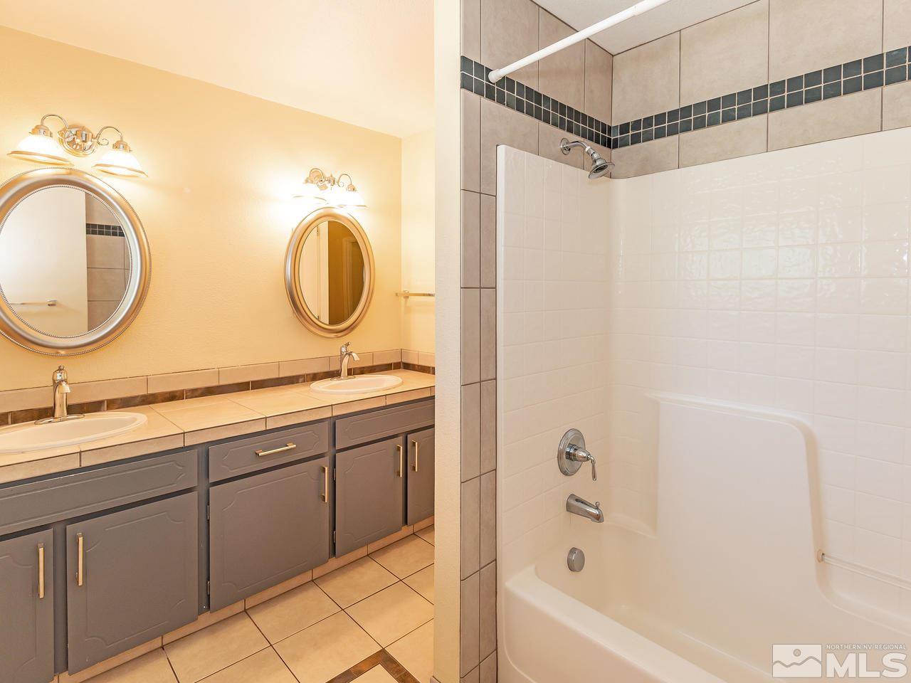 22870 Carriage Drive Reno, NV 89521 - Photo 15 of 16 a bathroom with a double vanity sink mirror and shower