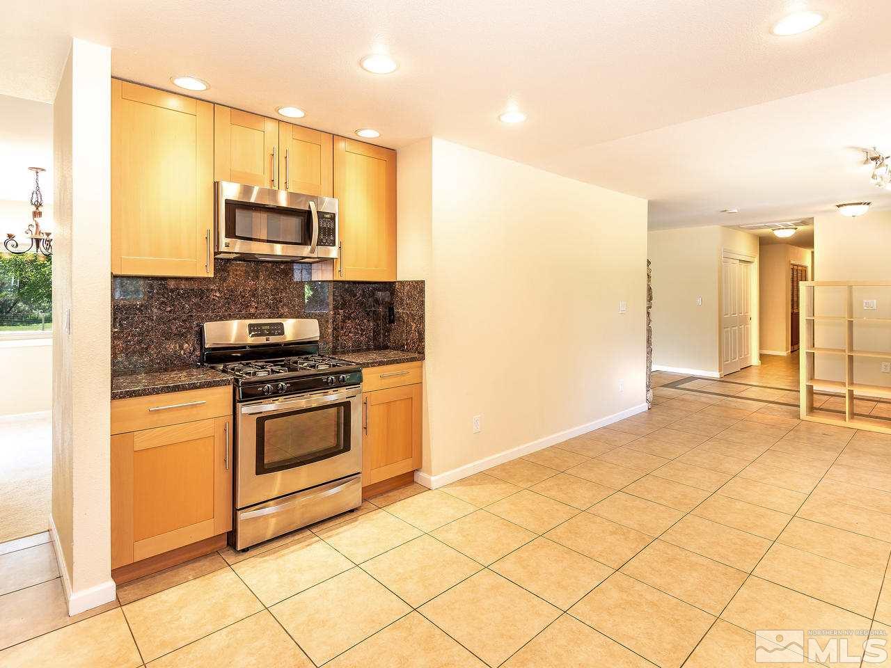 22870 Carriage Drive Reno, NV 89521 - Photo 9 of 16 a kitchen with stainless steel appliances a stove a microwave a sink and cabinets