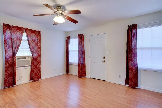 a view of a room with wooden floor and ceiling fan