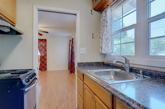 a kitchen with stainless steel appliances granite countertop a sink stove and a refrigerator