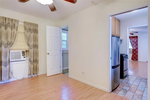 an empty room with ceiling fan and window