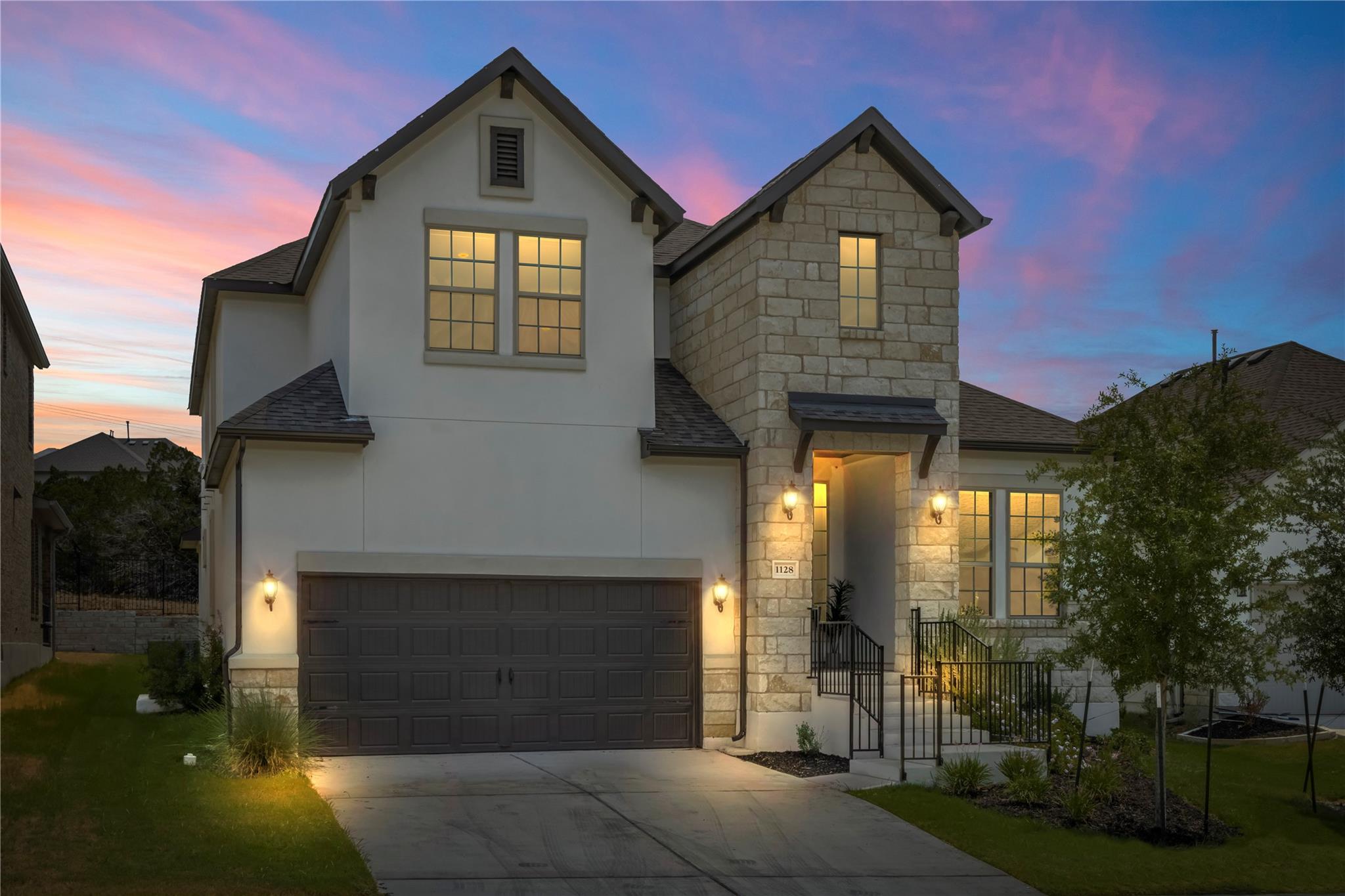 1128 Villa Rialto View Leander, TX 78641 - Photo 4 of 40 An inviting exterior with a charming blend of stone and stucco finishes under a twilight sky.